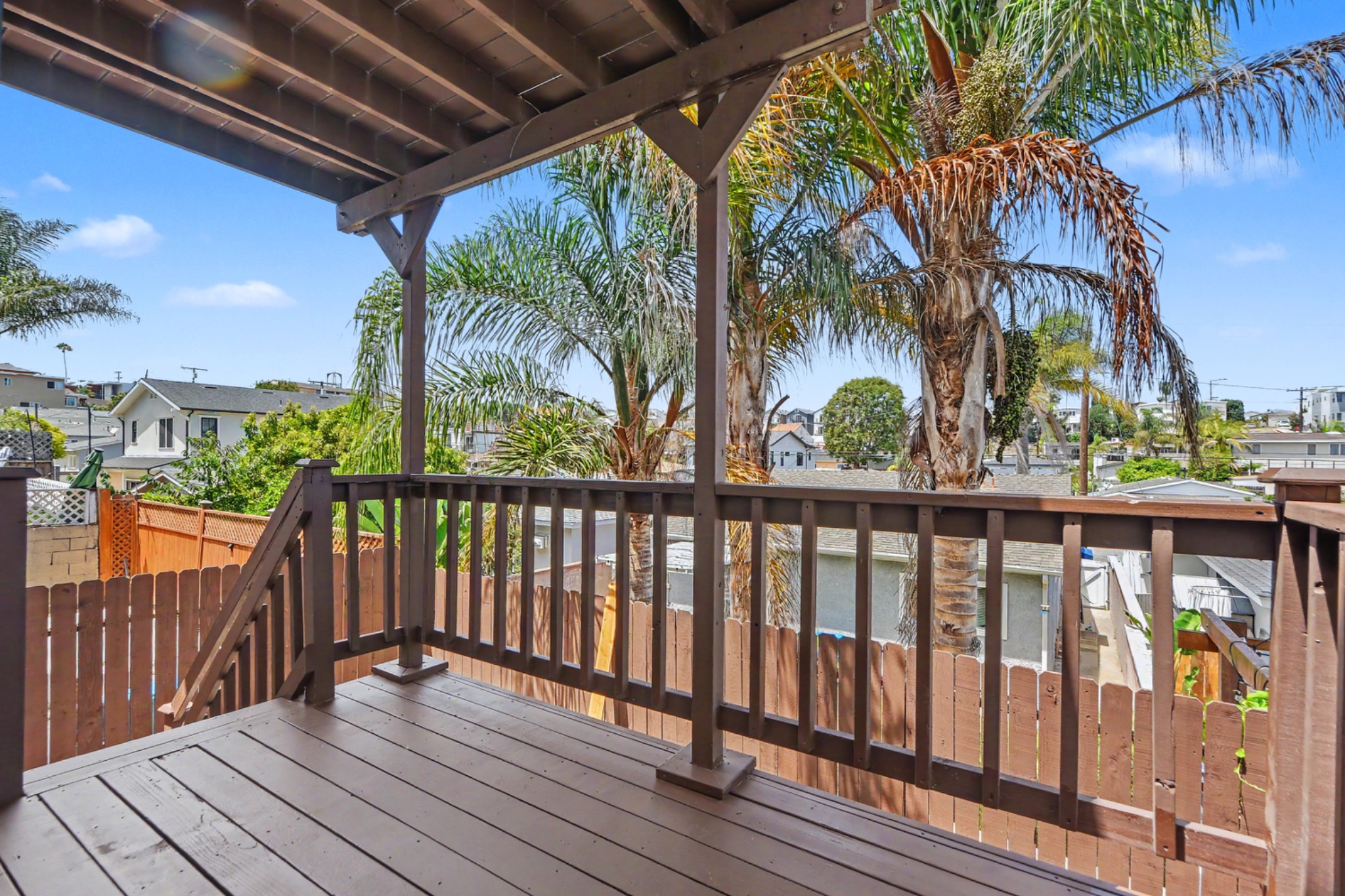 Covered rear patio overlooking palm trees