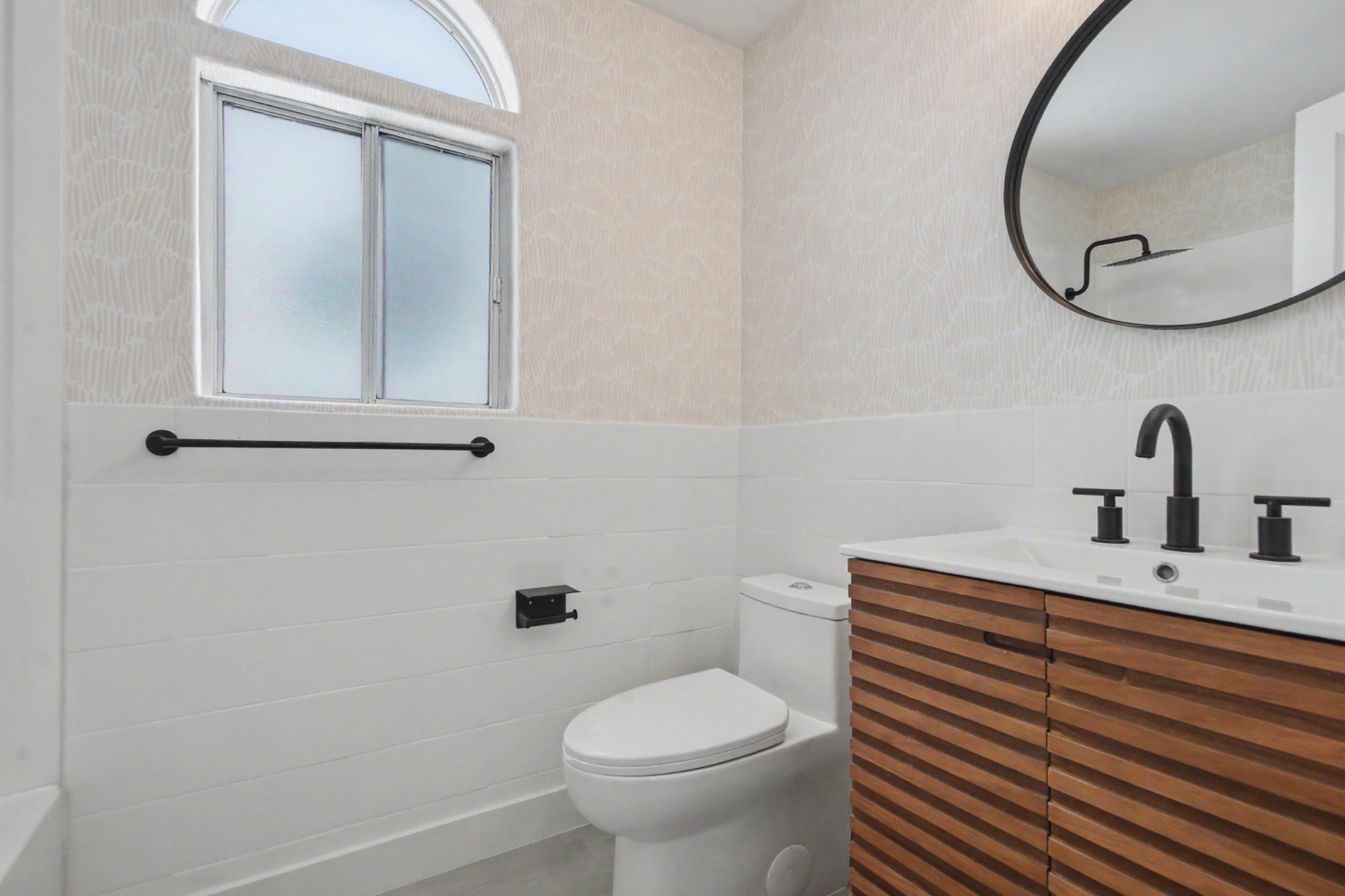 Updated lower bathroom with wood vanity and black fixtures
