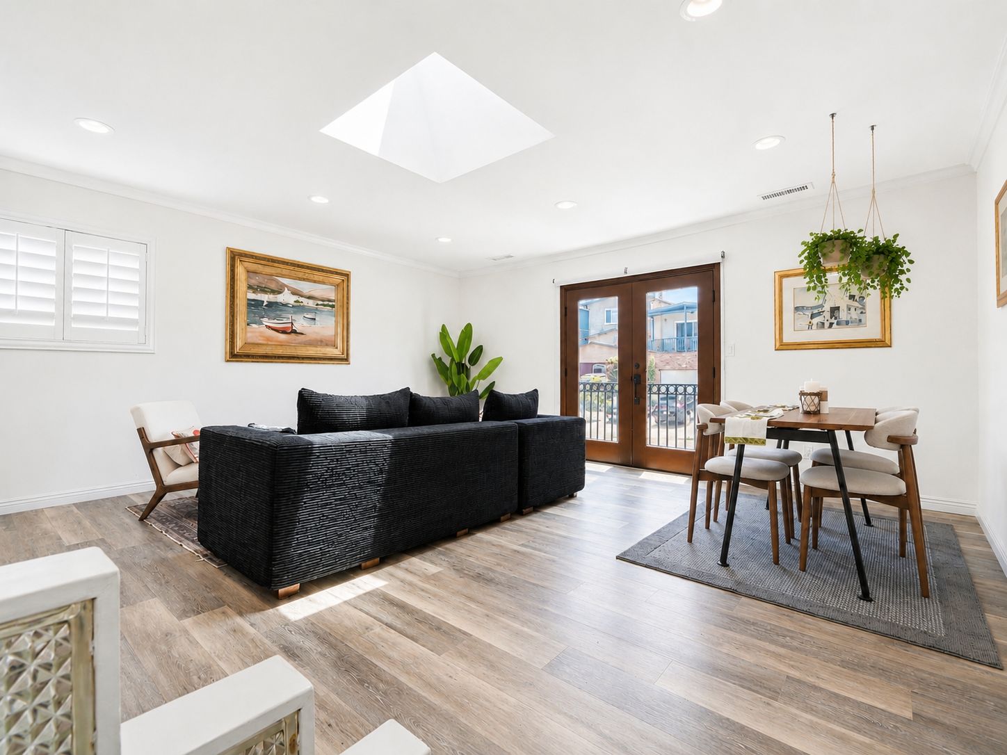Bright upper living and dining space with skylight and French doors